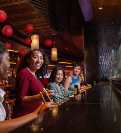 image of four people sitting at the sushi bar at luk fu