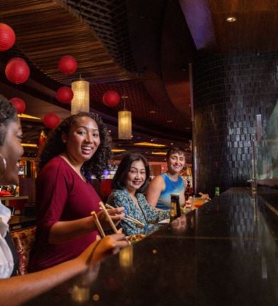 image of four people sitting at the sushi bar at luk fu