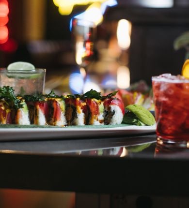 image of a festive sushi roll and festive cocktails at luk fu louisiana