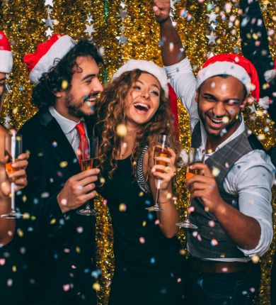 image of people celebrating with santa hats on and champagne