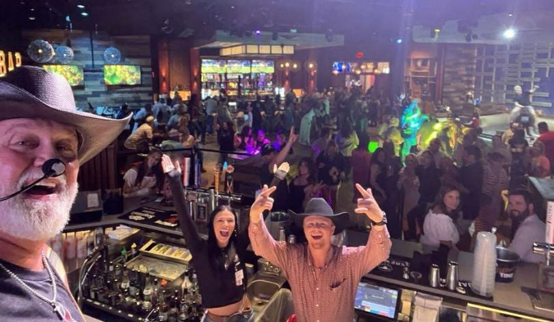 image of a man taking a selfie in front of a large crowd of people at pbr louisiana