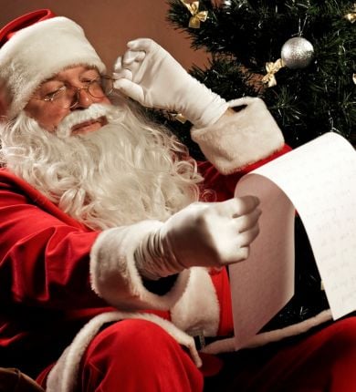 image of santa claus sitting on a chair holding a list