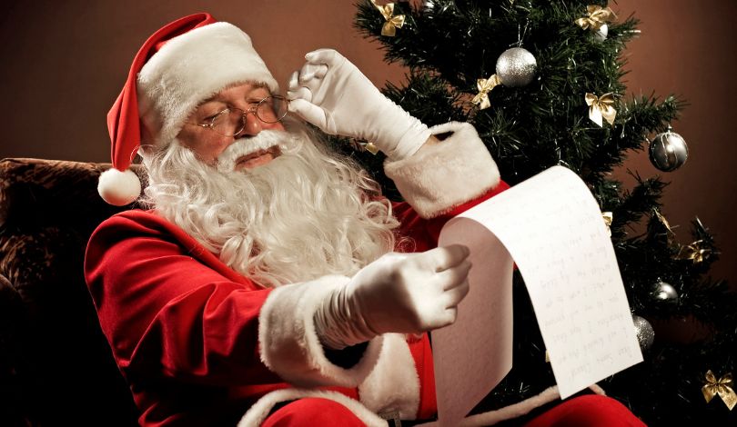 image of santa claus sitting on a chair holding a list