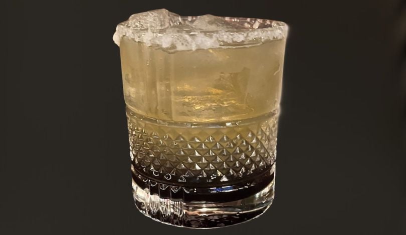 image of a purple and gold cocktail with a black background