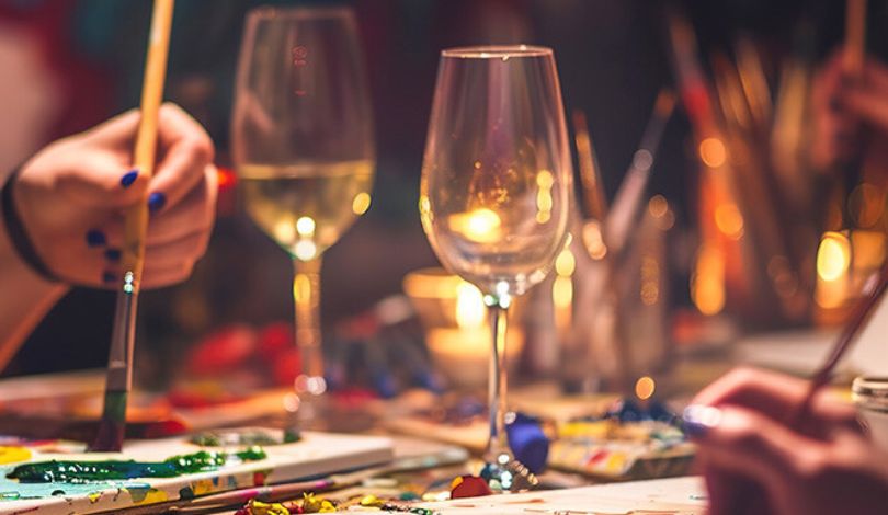 image of people painting with wine glasses in front of them