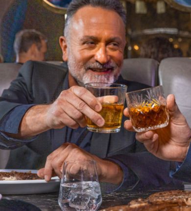 image of a man toasting a whiskey glass