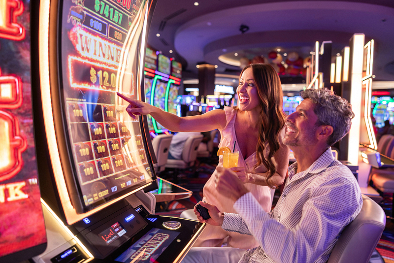 Couple playing at a slot machine