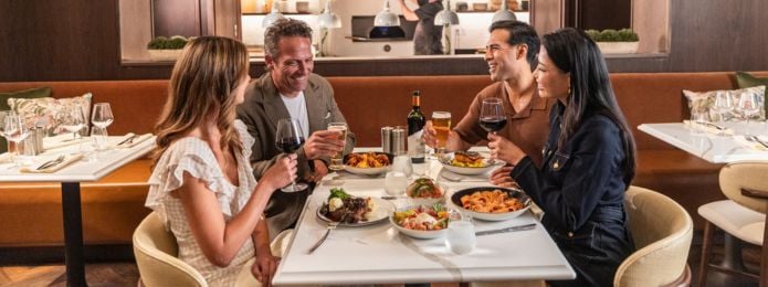 Two couples sitting down at Ridotto eating dinner and having drinks