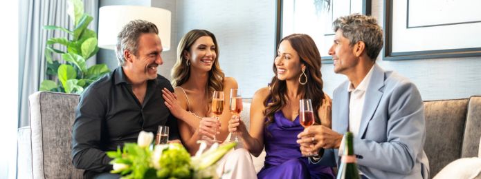 Two couples who are having drinks in their hotel room