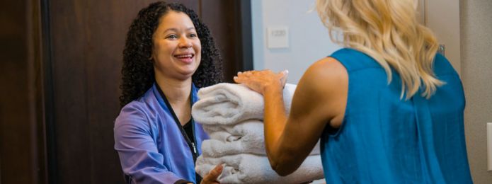 Housekeeper handing a guest towels