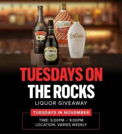 November Tuesdays on the Rocks. 4 different types of liquor sitting on wooden stands with a blurry bar background.