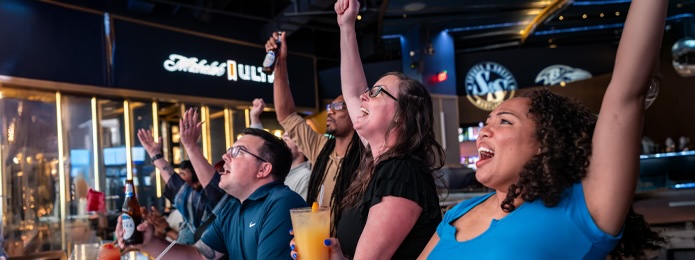 fans at a table eating food and cheering