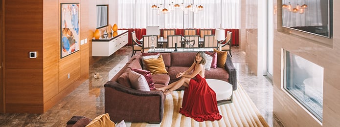A female guest relaxing on a sofa in a large luxurious suite