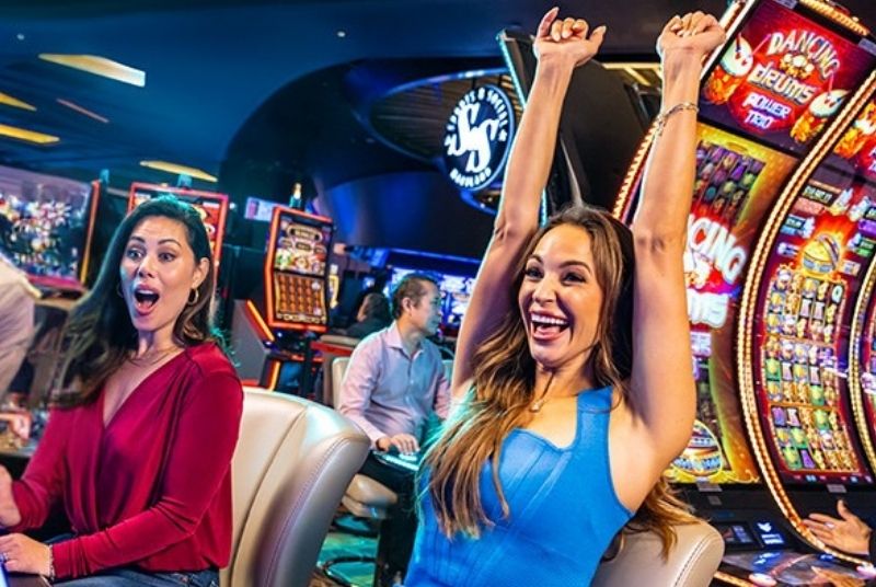 Guests playing on slot machines and celebrating hitting the jackpot.