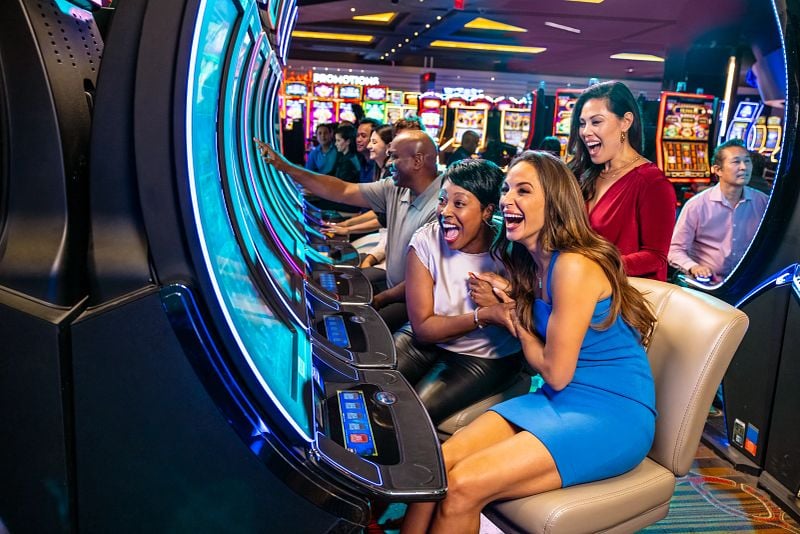 Guests playing on slot machines and celebrating hitting the jackpot.