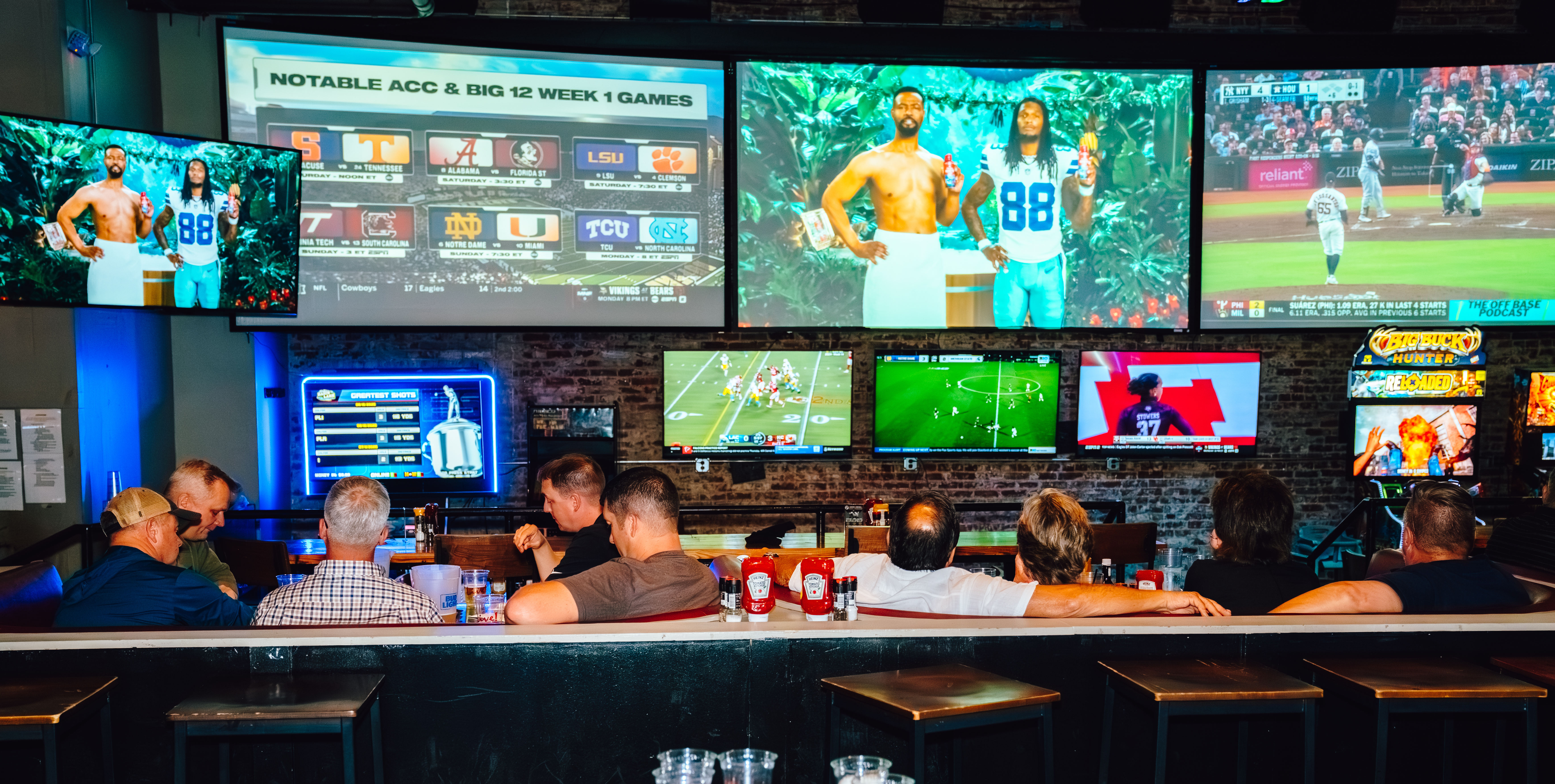 An image of people watching football on the big screens at Sports and Social.