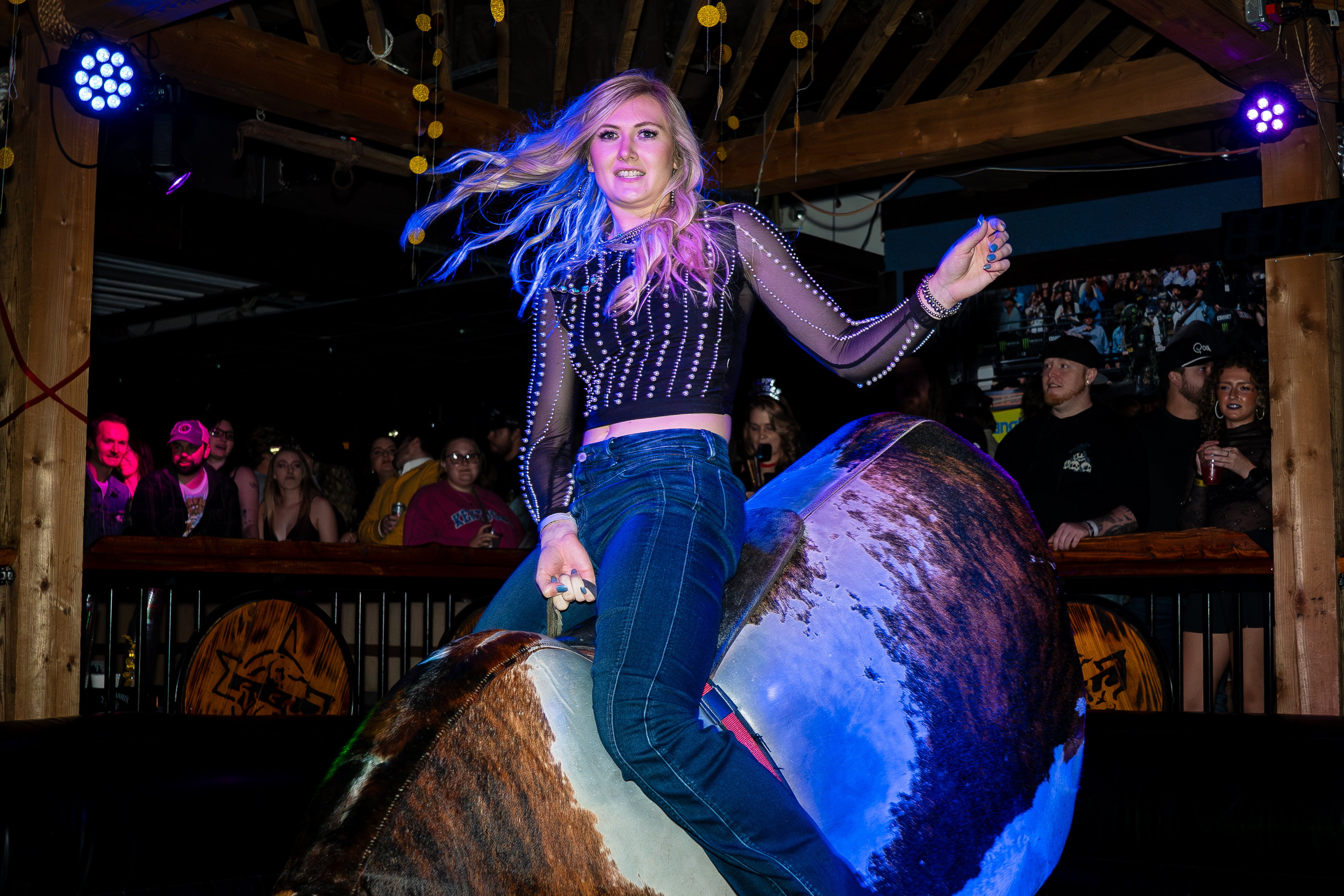 An image of a woman riding a mechanical bull.