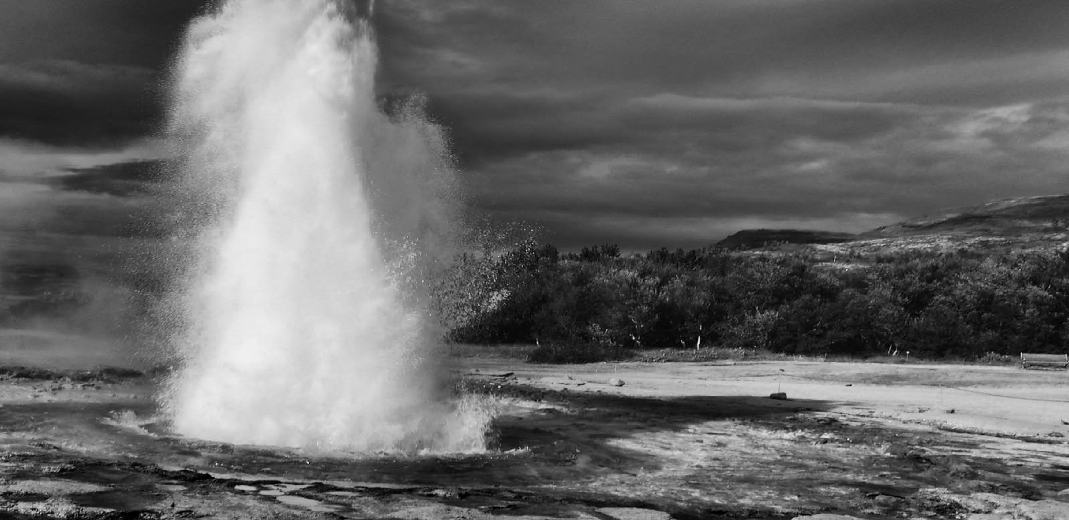 Eruption of geyser against clouds