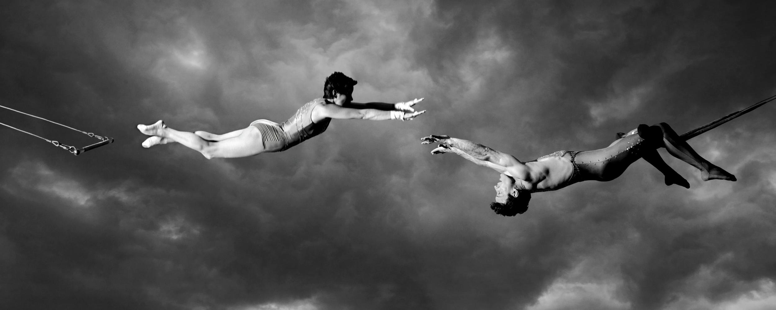 trapeze artists performing dangerous maneuvers