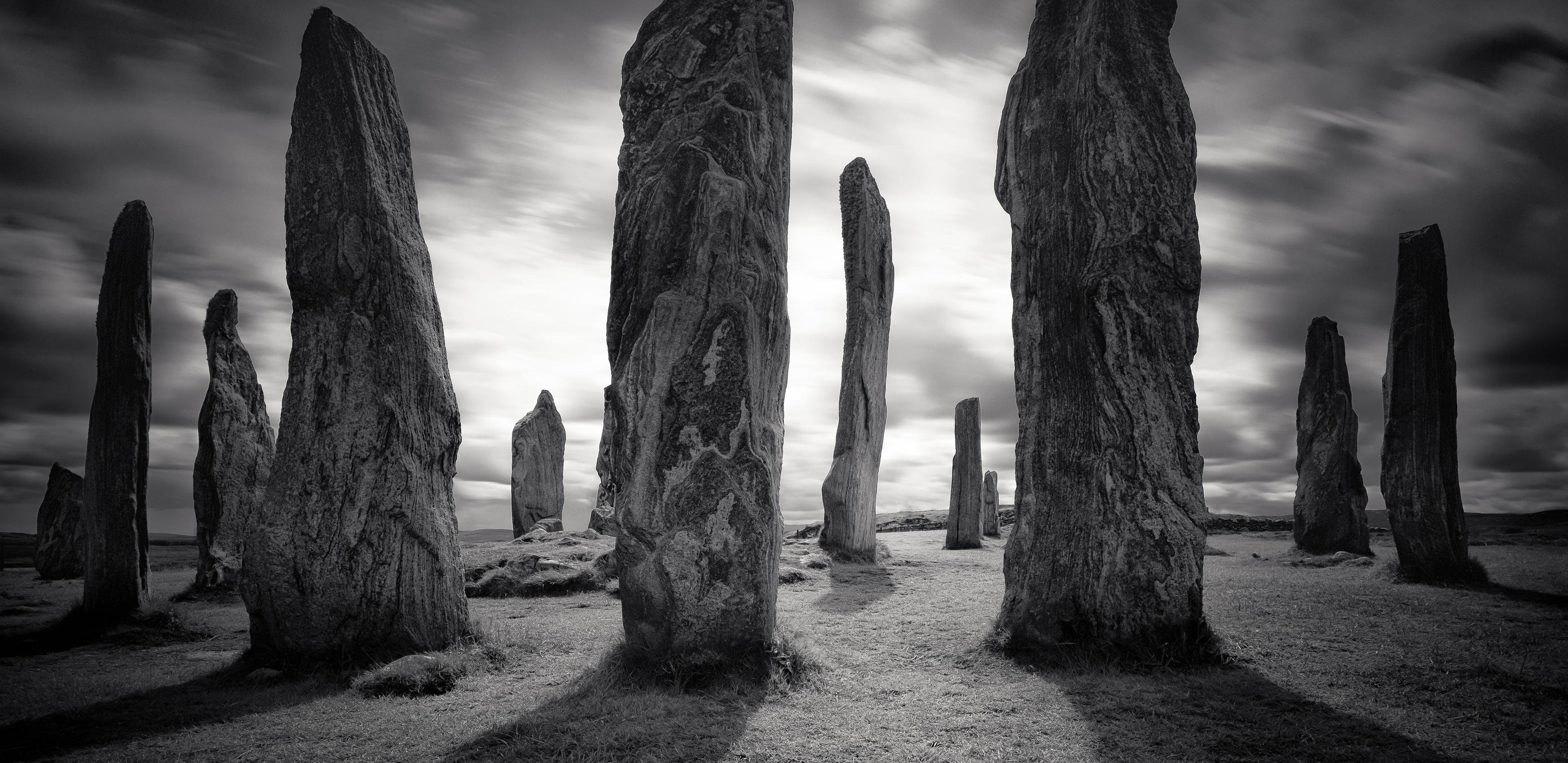 Callanish Standing Stones. Depicted in black and white and using long exposure to create an eerie atmosphere the stones cast long shadows in the sunlight.