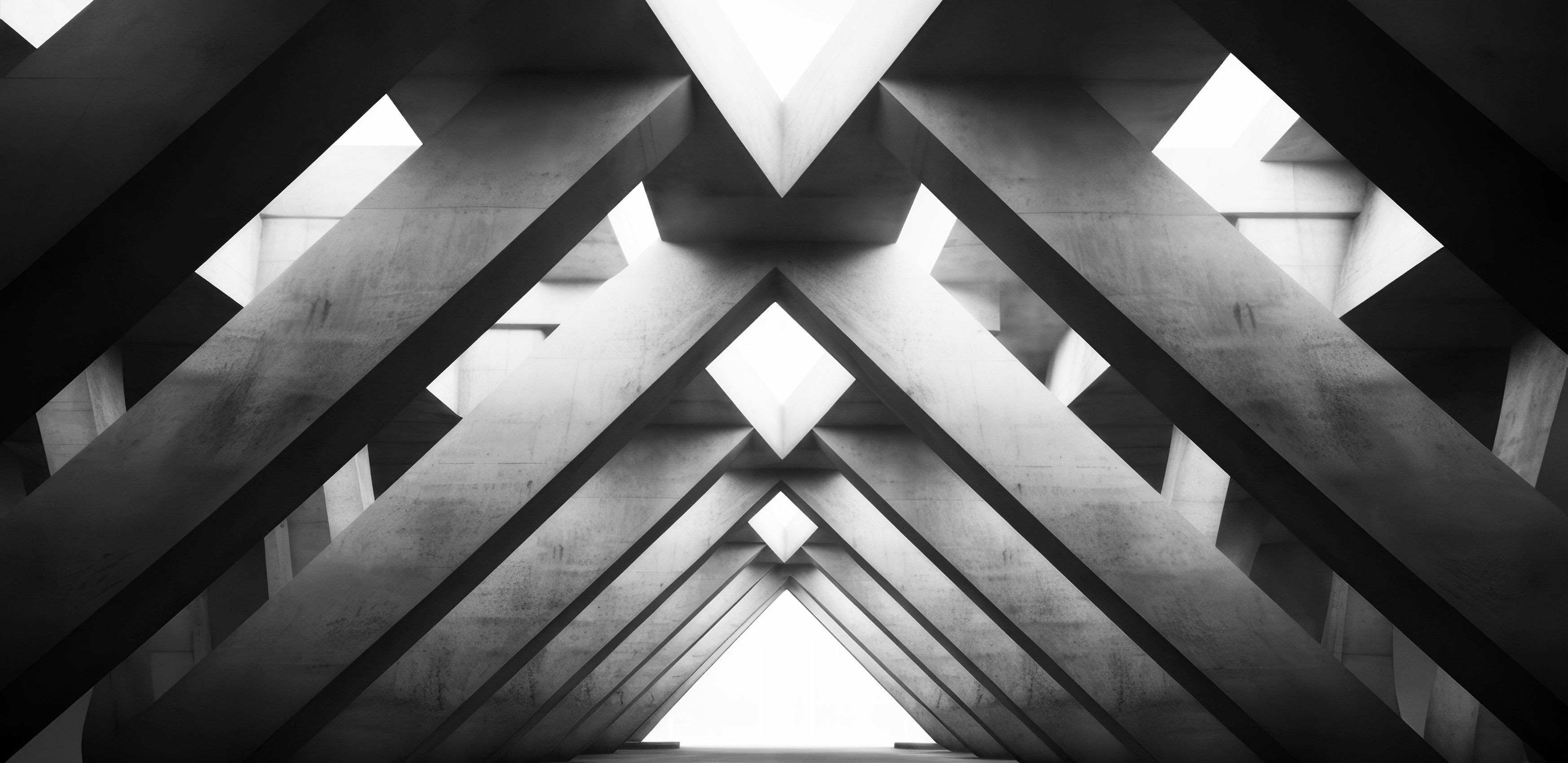 Concreate beams leaning in to each other to form an archway