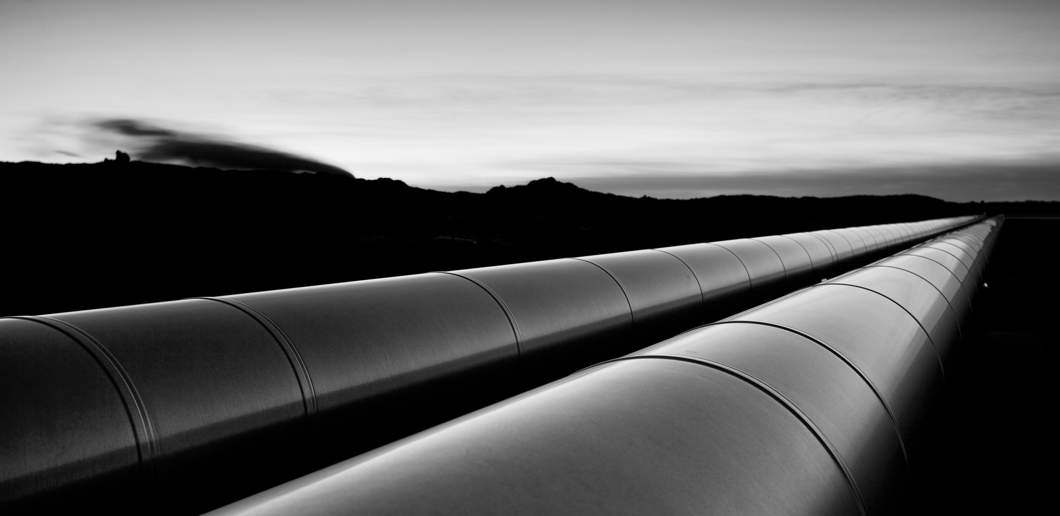 Two large shiny metal pipes from Reykjanesvirkjun geothermal power station in Iceland.