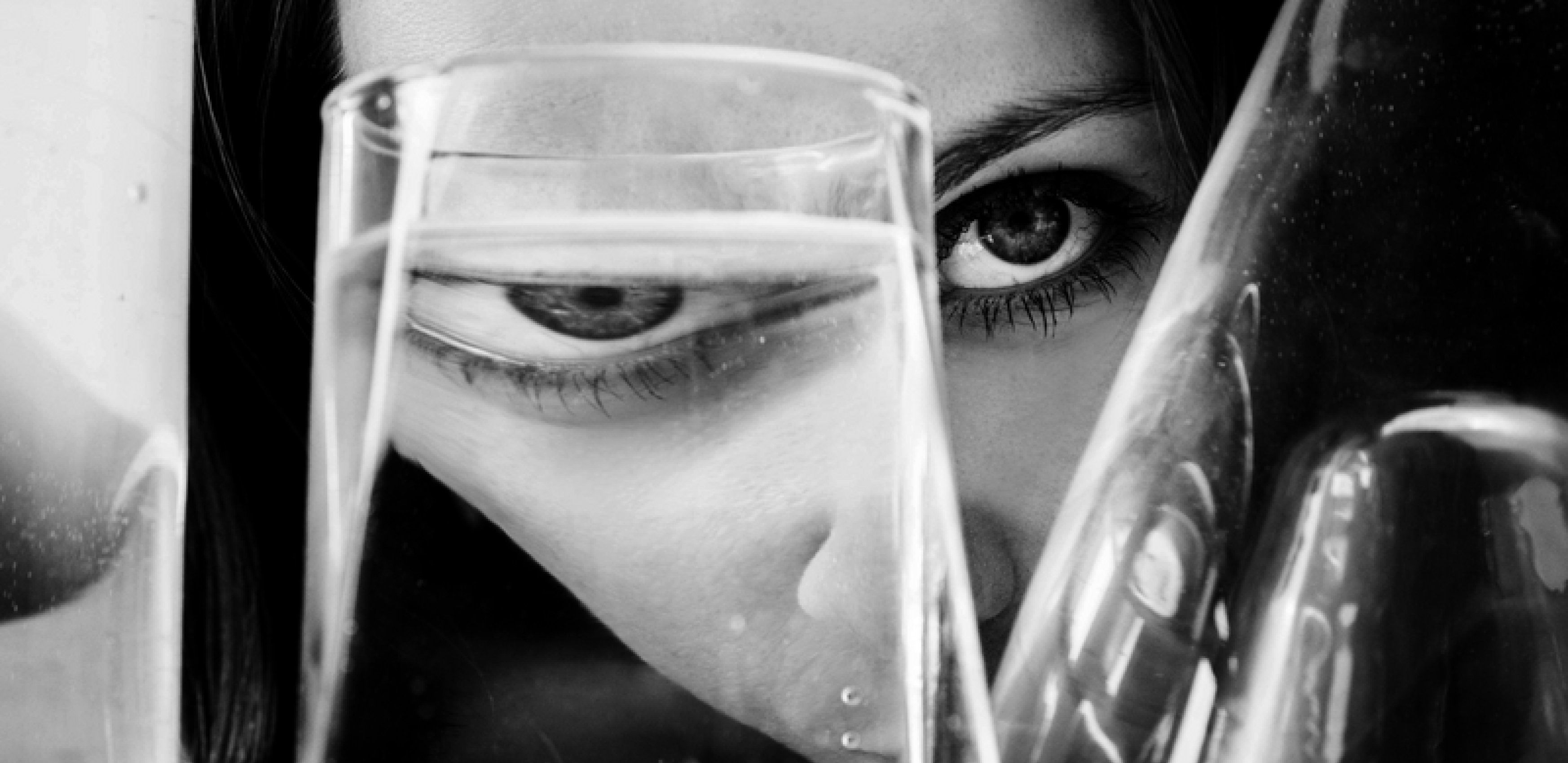 Close up of a females eye looking through a glass of water