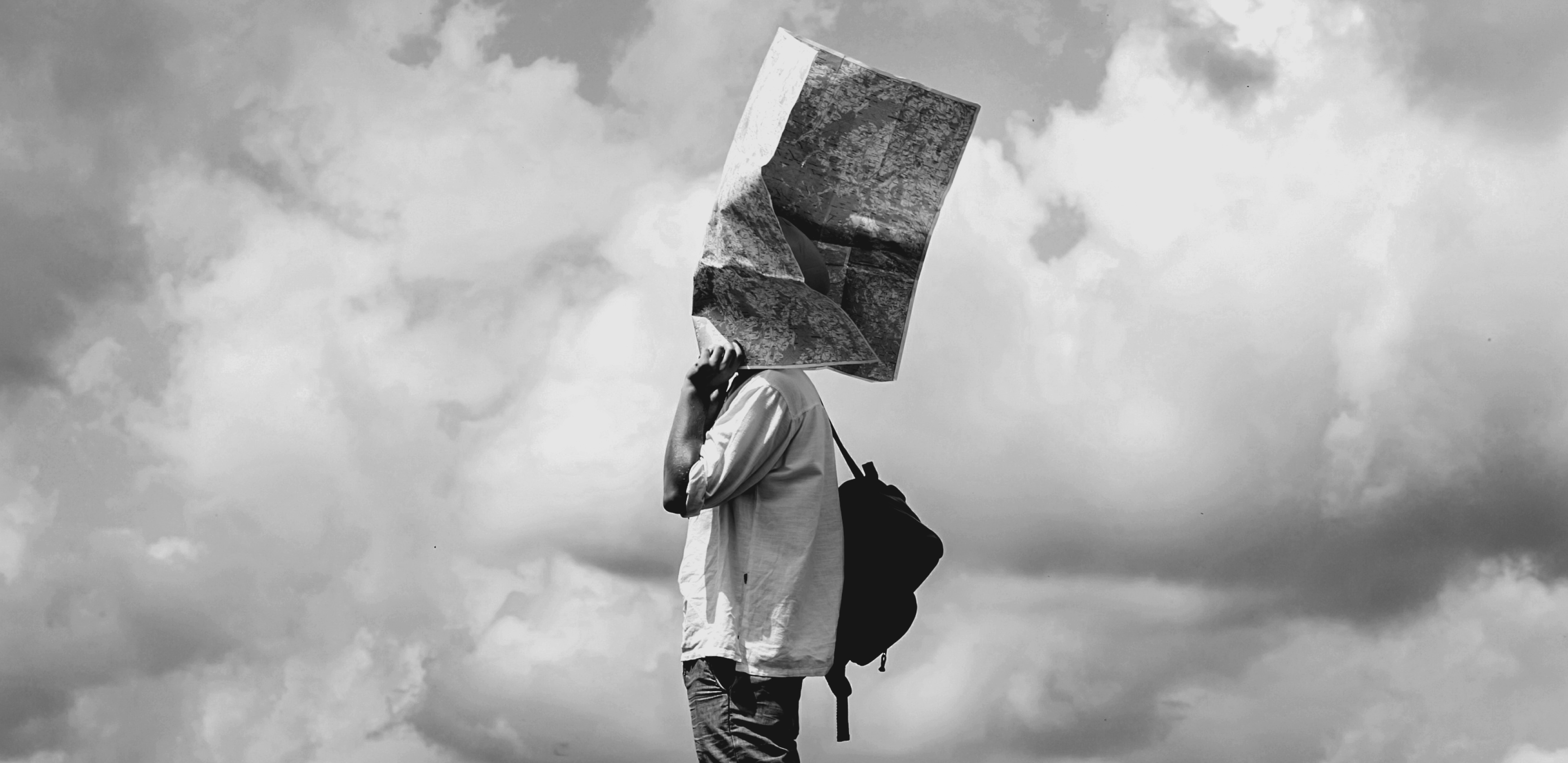 A traveller with a map blowing over their face