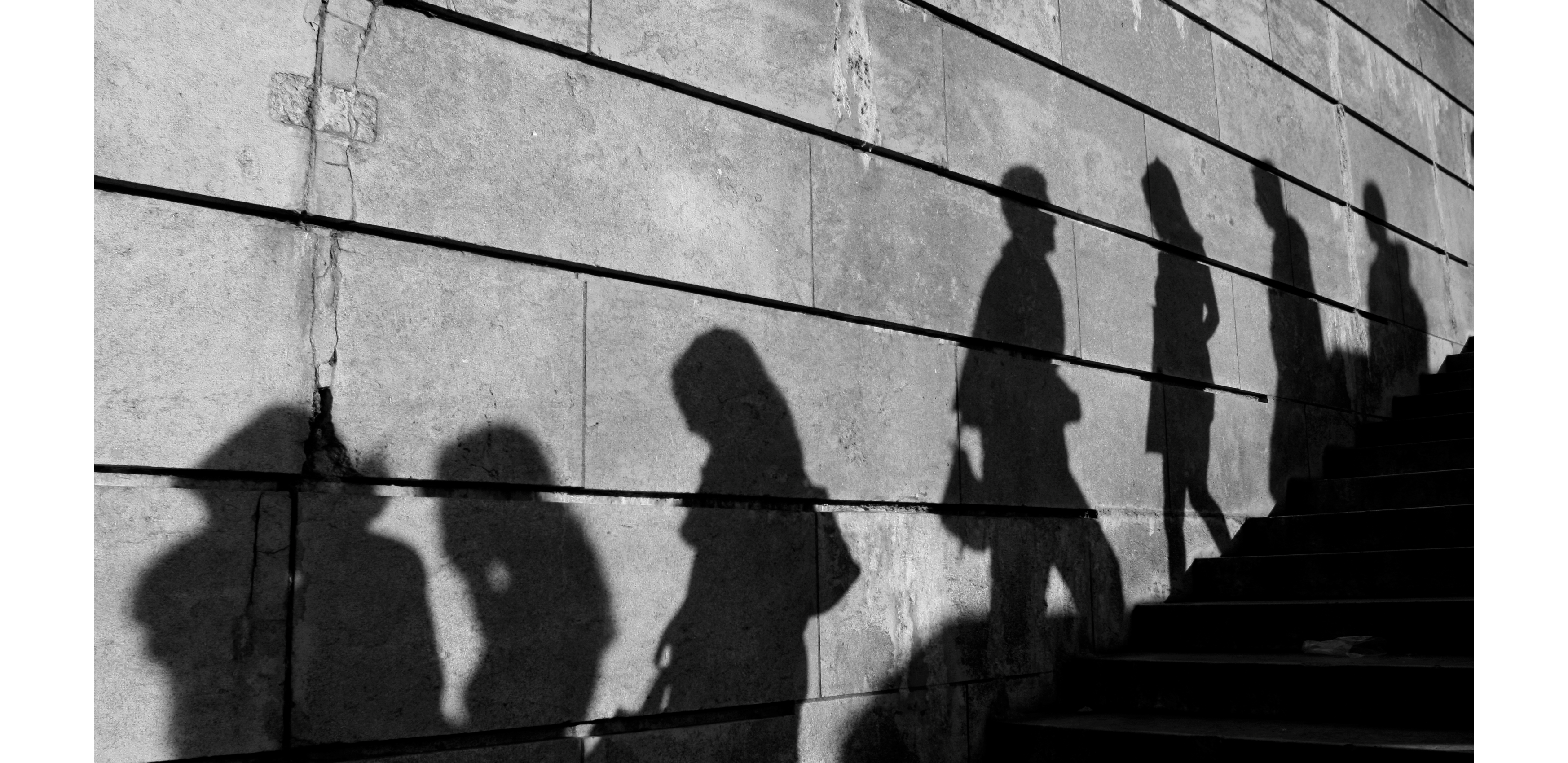 Shadow of people walking up and down an outdoor staircase