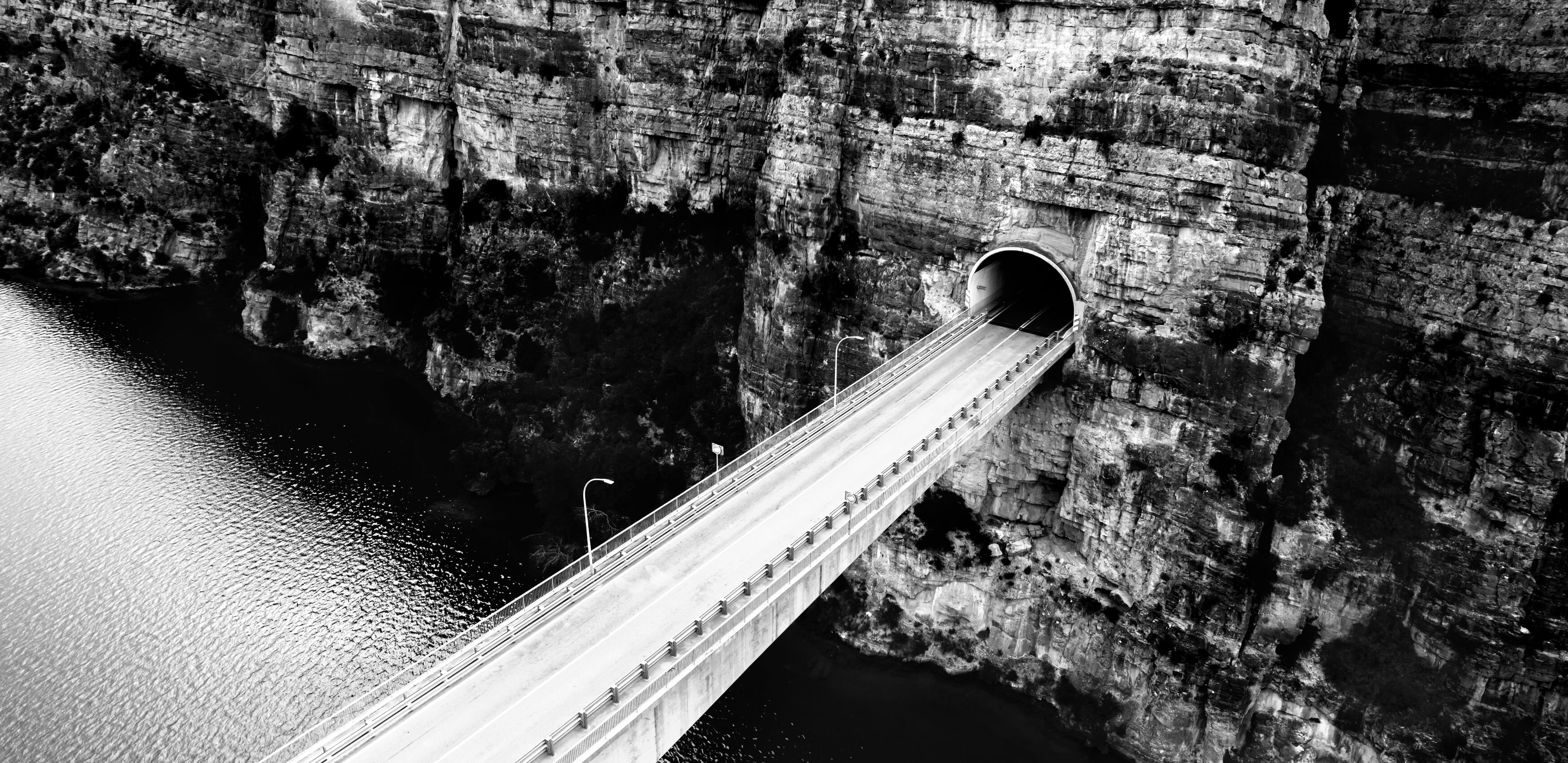 Bridge over river going into mountain side tunnel