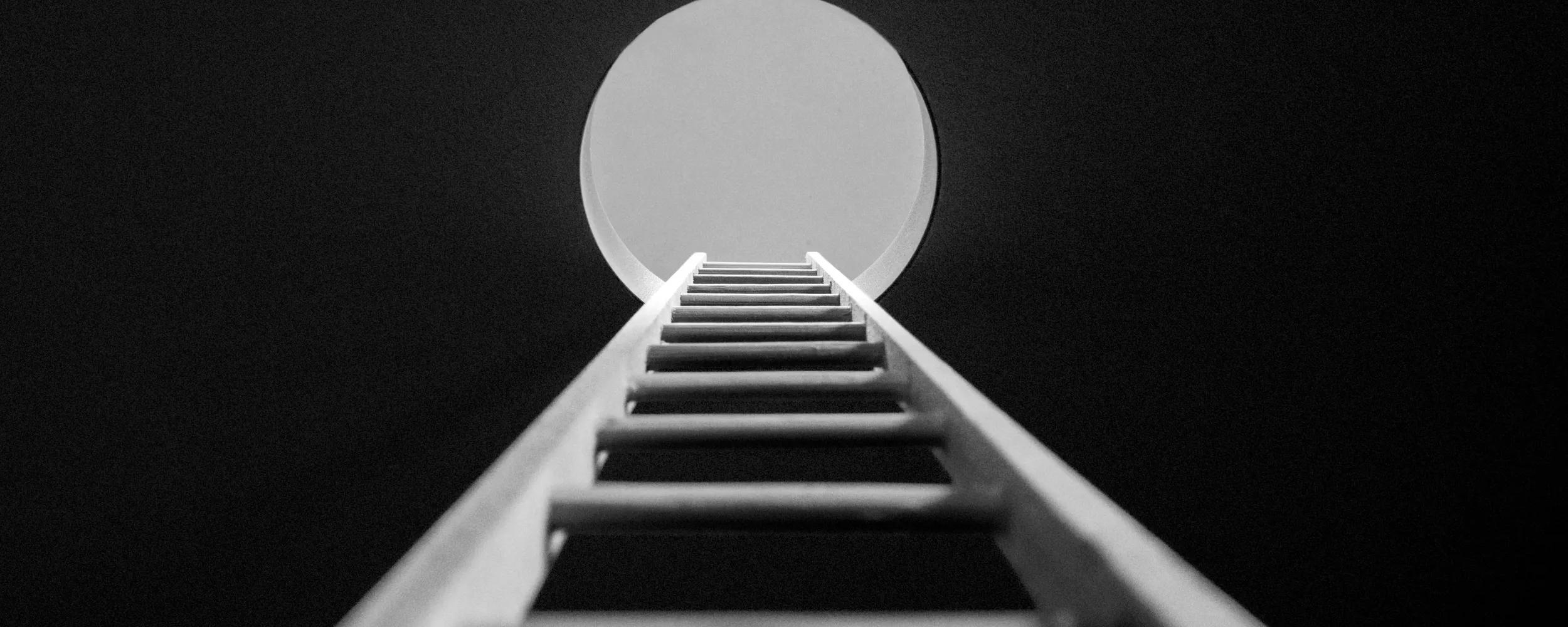 Point of view, looking up ladder sticking through hole in ceiling revealing the sky