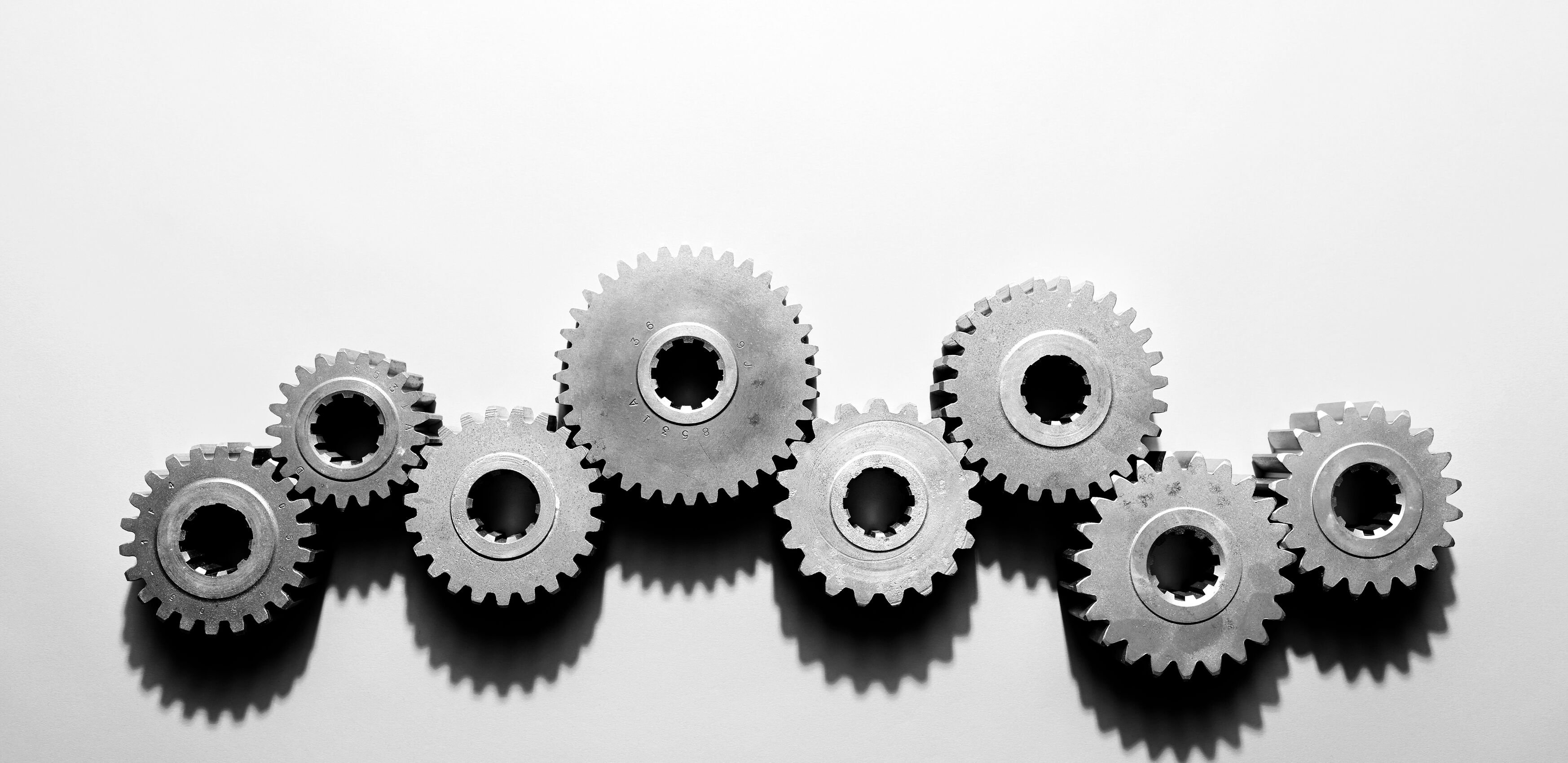 Eight cogs, sitting on a table all connected