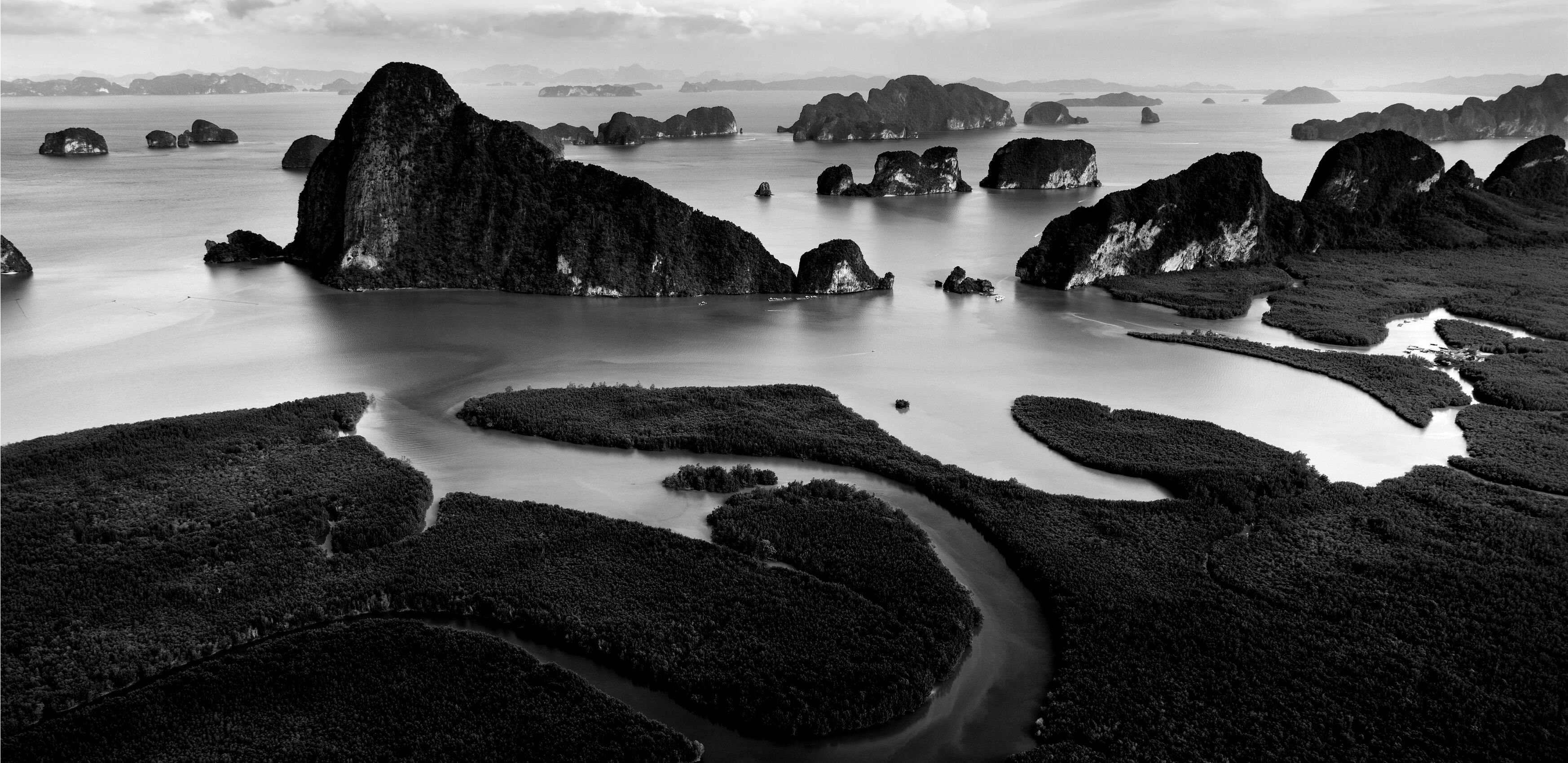 River and marsh land going into sea with rocks throughout