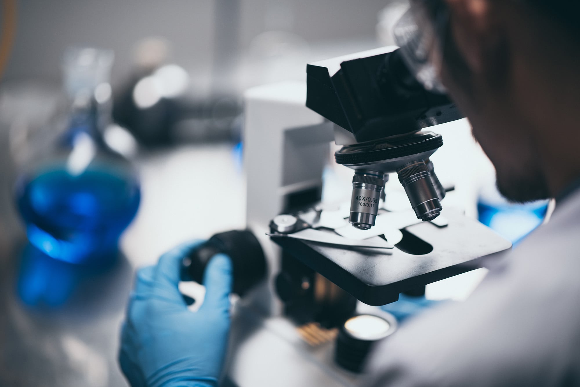 A scientist is conducting research in a laboratory using a microscope and unknown samples.