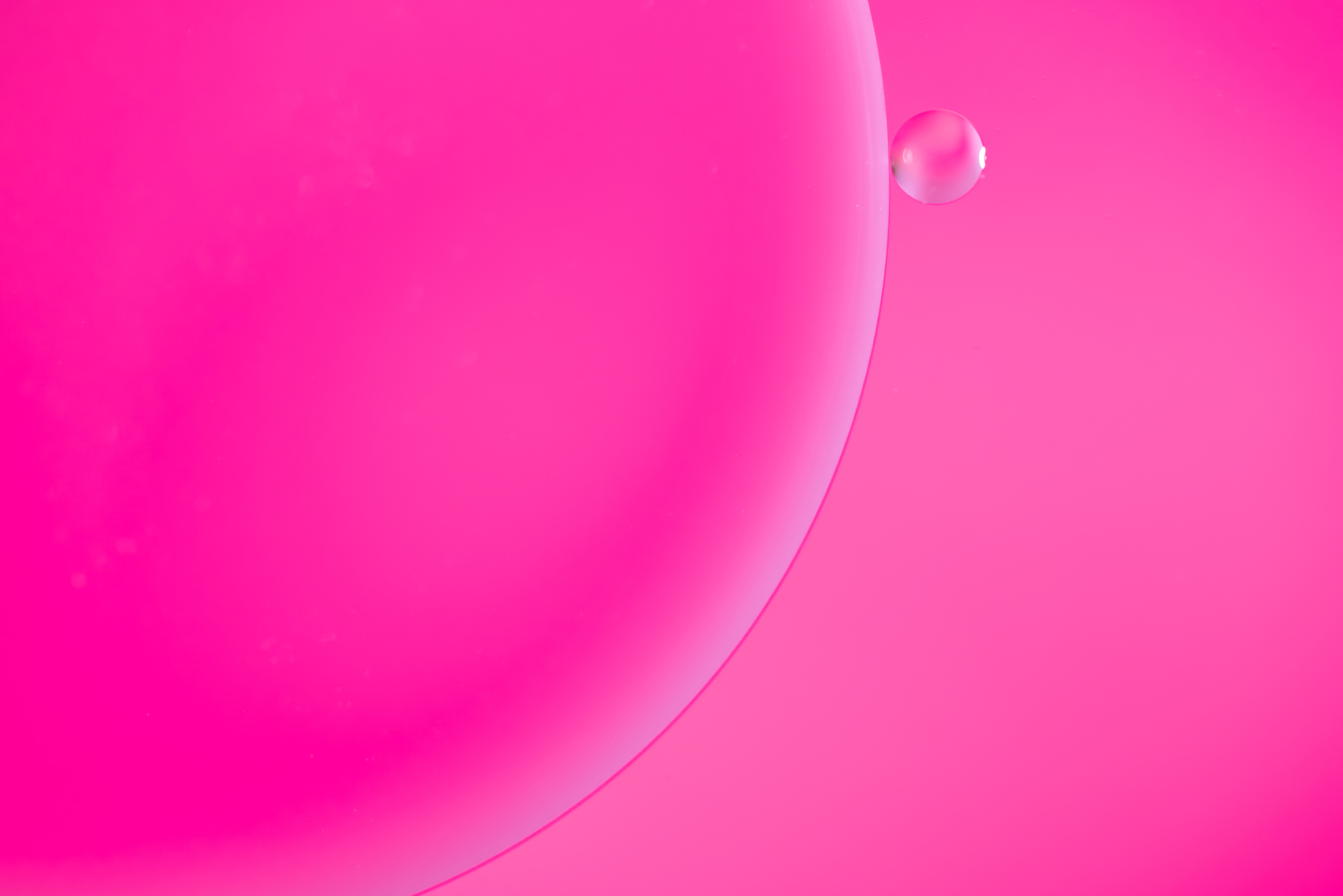A large pink sphere sits in the left side of the image with a smaller pink sphere to its upper right.