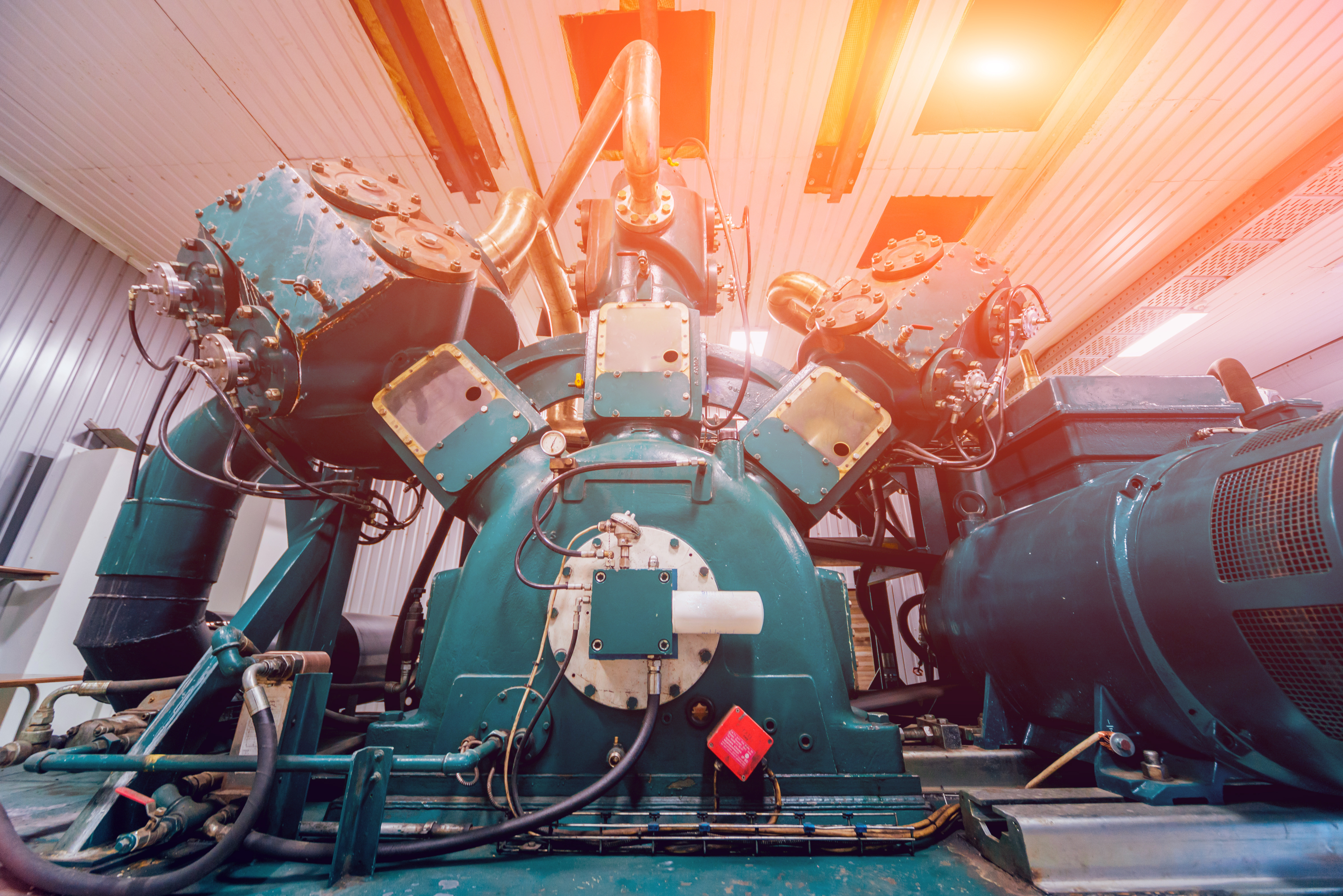 A large, powerful, industrial engine has a large number of gears and pulleys.
