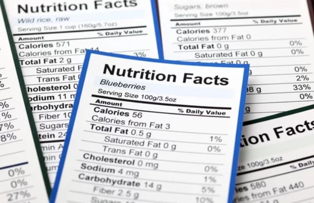 Nutrition Facts Labels for Various Foods Close-up image of multiple nutrition facts labels for different food items, with a focus on the label for blueberries.