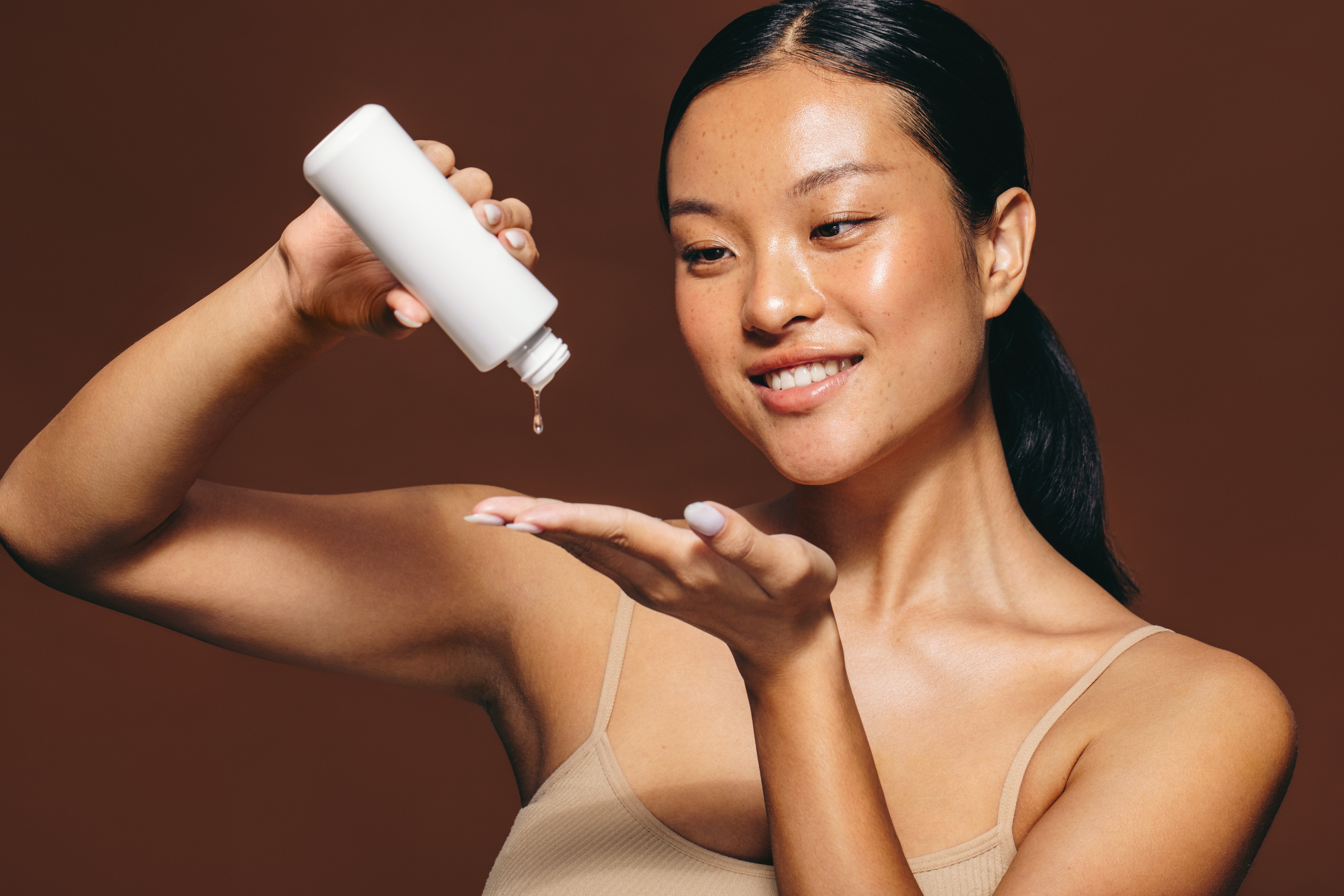 Painelista de testes clínicos derramando soro facial de um frasco na mão