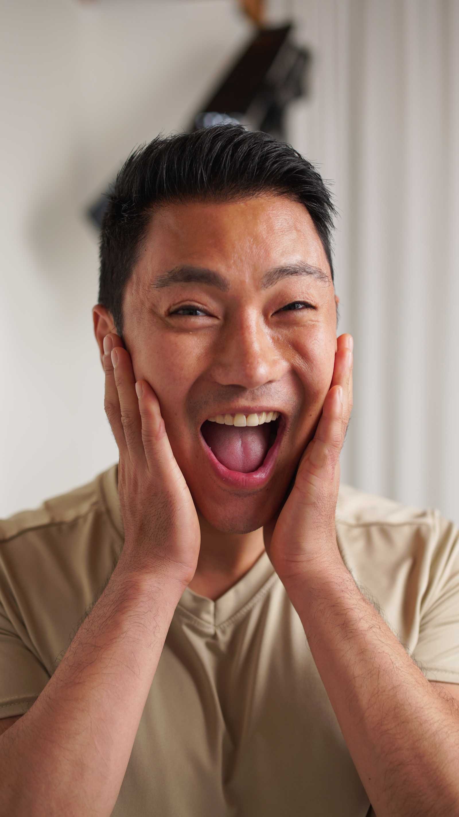 Clinically testing panelist excitedly smiling with his hands on his cheeks
