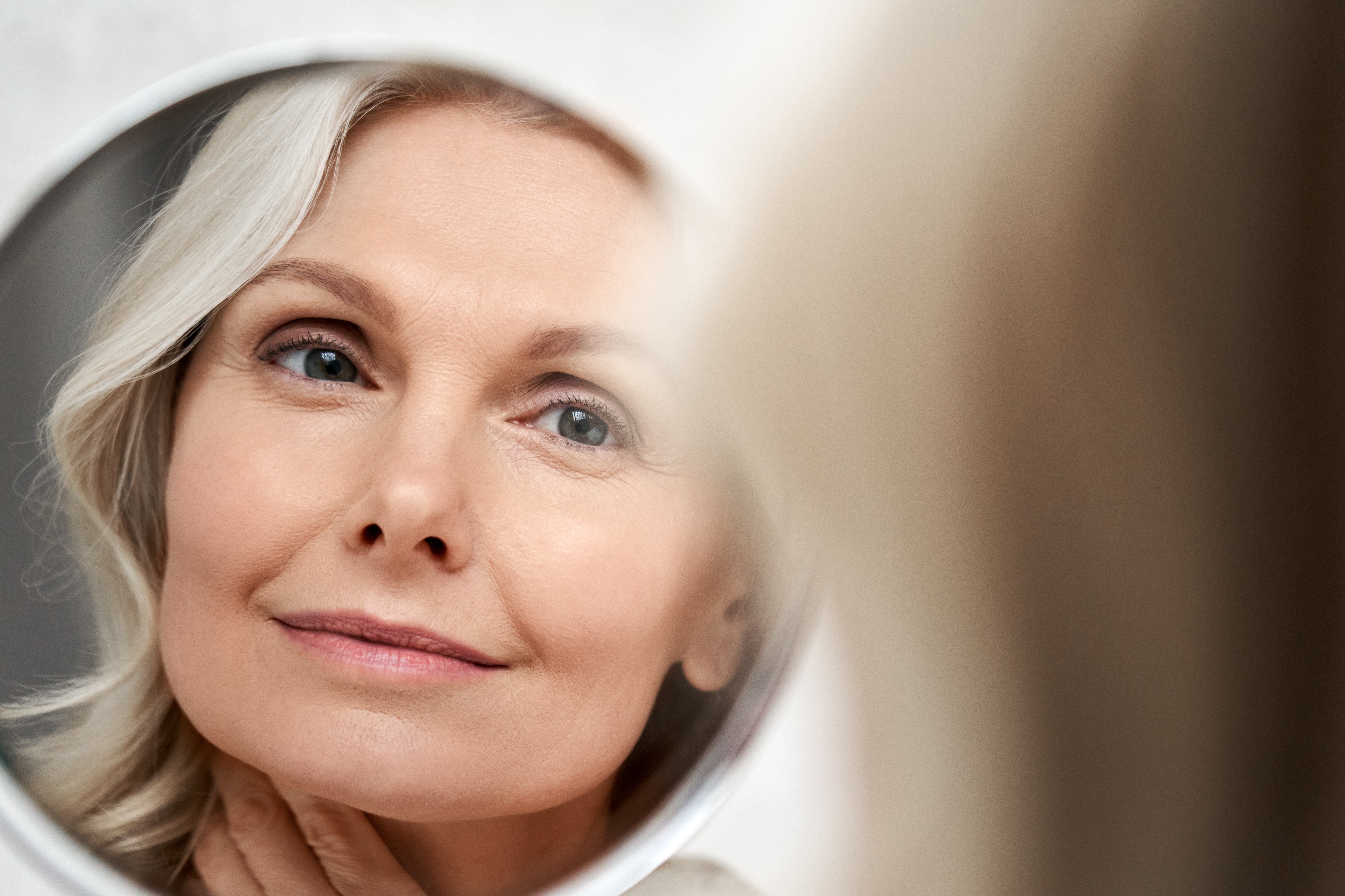 Female clinical testing panelist looking into a mirror