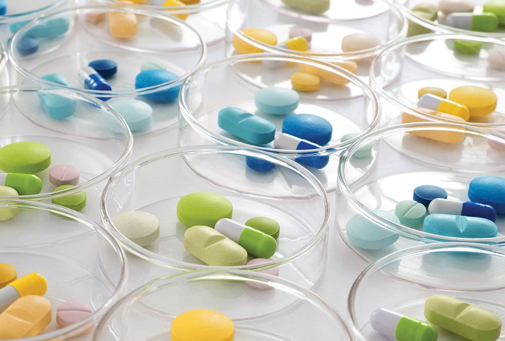 Various pills are organized in petri dishes for testing or analysis.