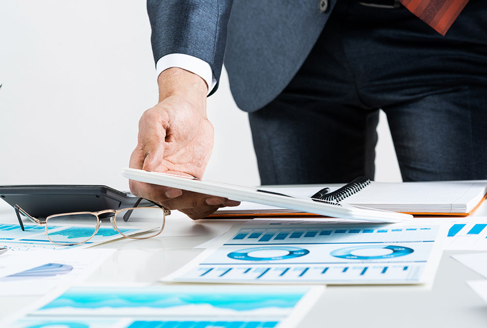 A businessman is analyzing financial data using a tablet computer.