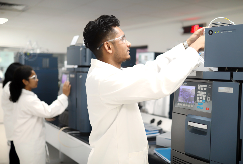 Two chemists work on advanced laboratory equipment during research and development of a new product.