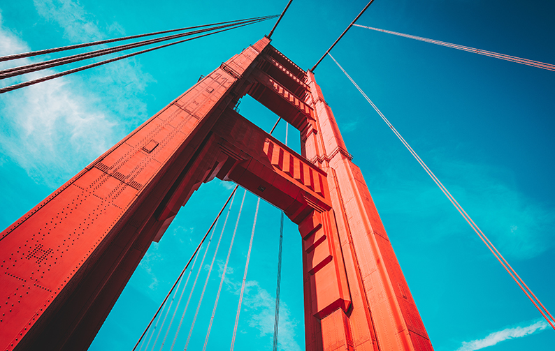 A close-up view of the Golden Gate Bridge with blue sky in the background.