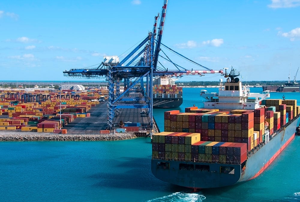 A large container ship is being loaded at a busy port.