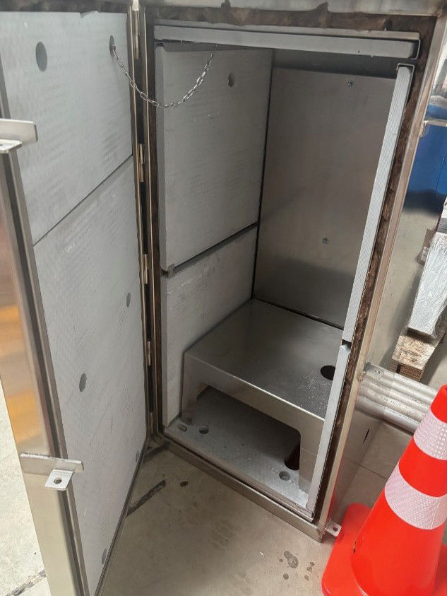 Industrial stainless steel control cabinet in workshop.