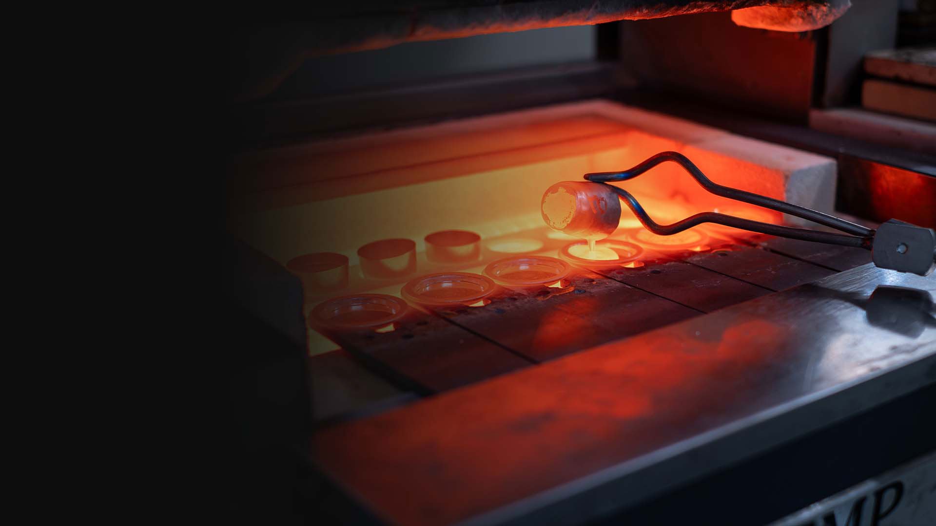 Tongs removing crucible from furnace in a Metallurgy laboratory