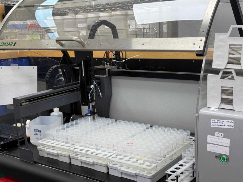 Automated laboratory analyzer processing rows of sample tubes in a lab