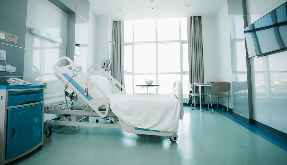 Quarto hospitalar moderno e equipado Quarto hospitalar moderno com cama articulada e equipamentos clínicos.