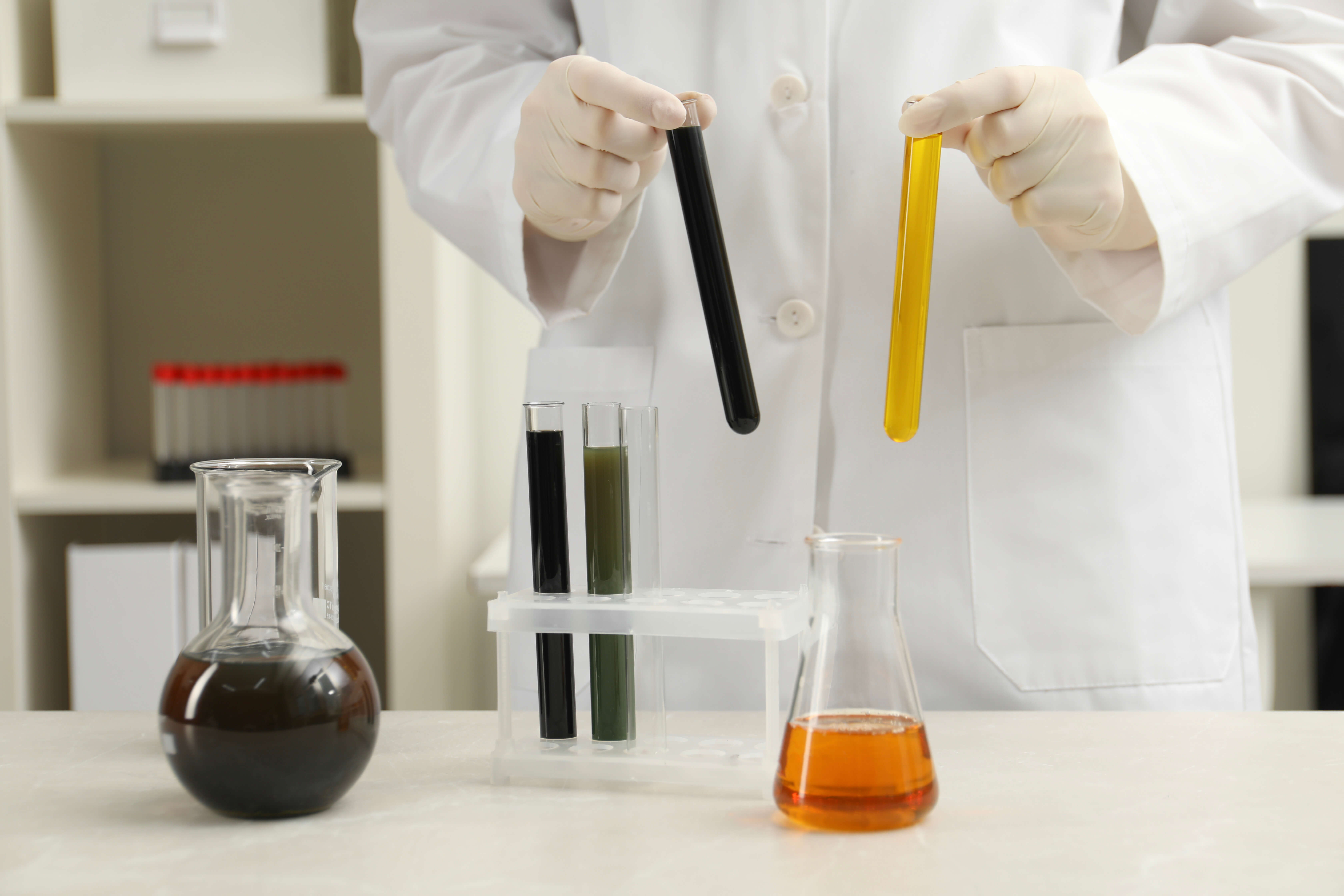 Laboratuvarda Kimyasal Numune Analizi Laboratuvar ortamında farklı renklerde sıvılar içeren test tüplerini tutan kişi